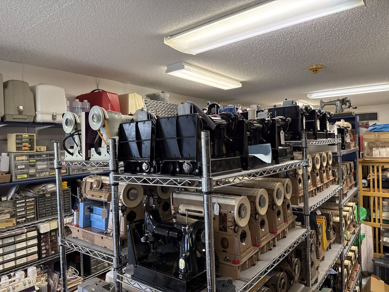 Wall of vintage sewing machines in inventory at AAA Ember Sewing Machines